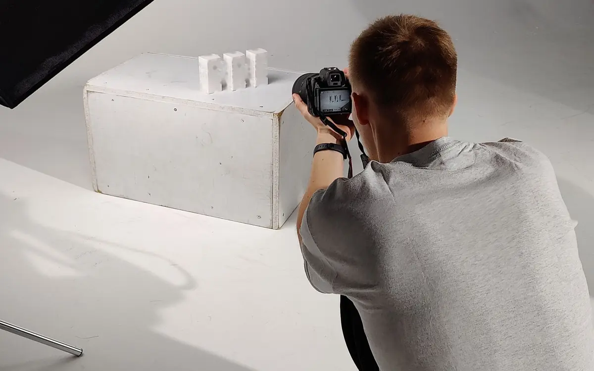 Example of a photographer shooting product boxes on a white studio set under a softbox
