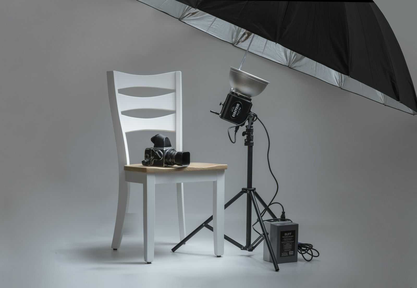 Example of a product photo setup on a white backdrop with a studio light and umbrella
