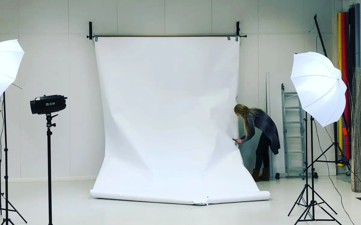 Example of a photo studio with a white seamless backdrop, light stands and umbrella lights